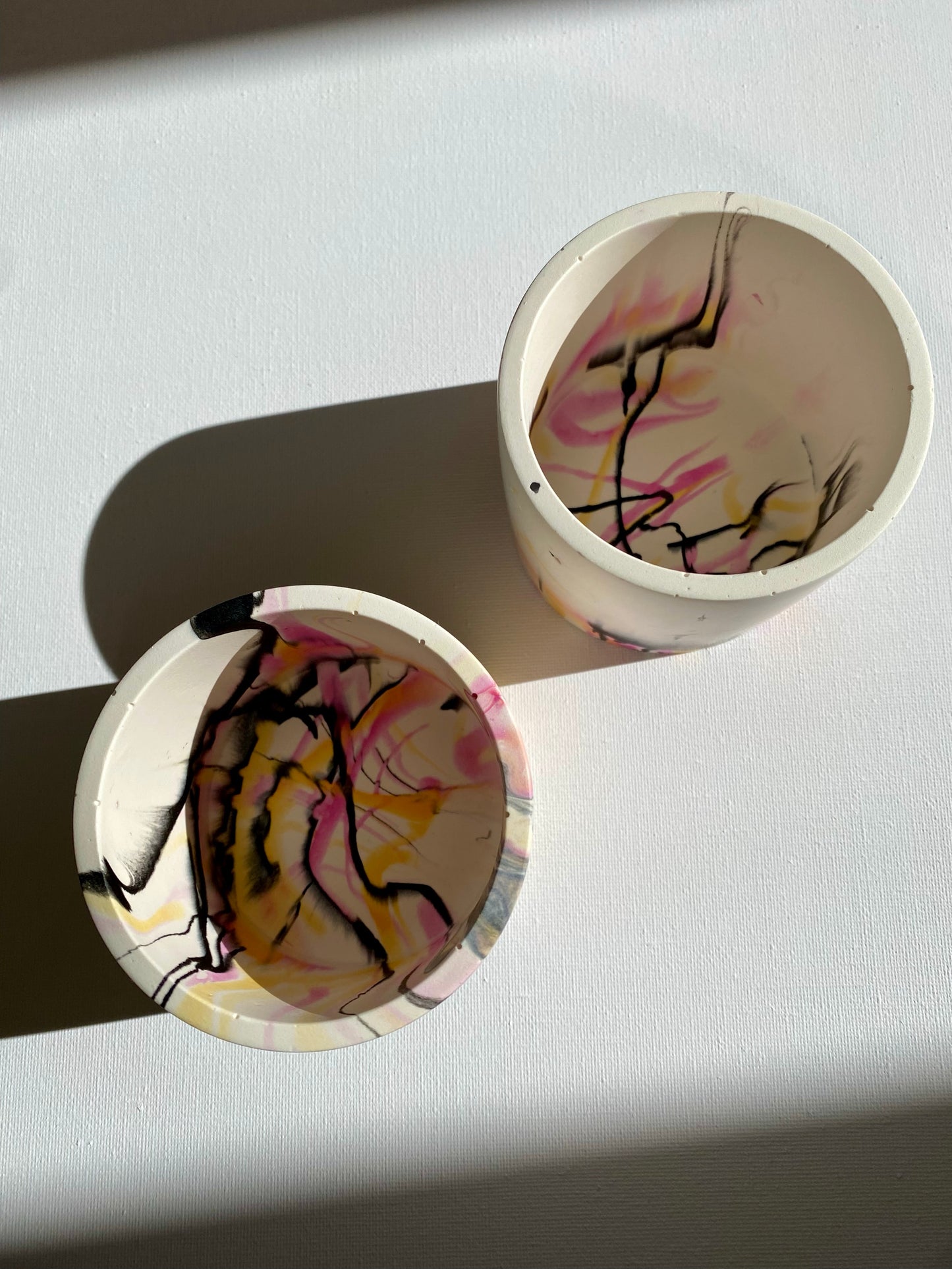 B. White, pink, orange and black abstract pot