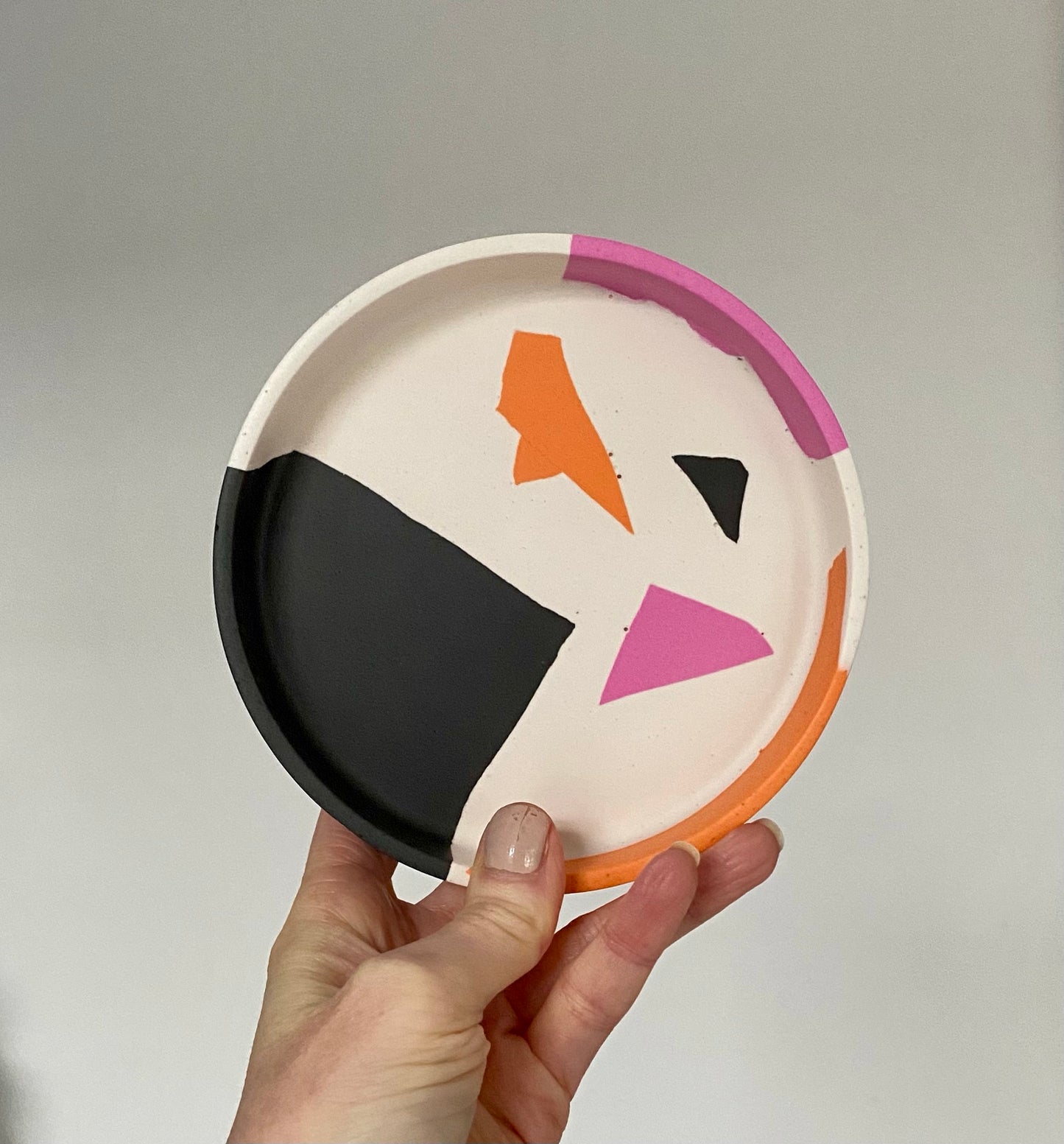 B. White, pink, orange and black geometric Plate